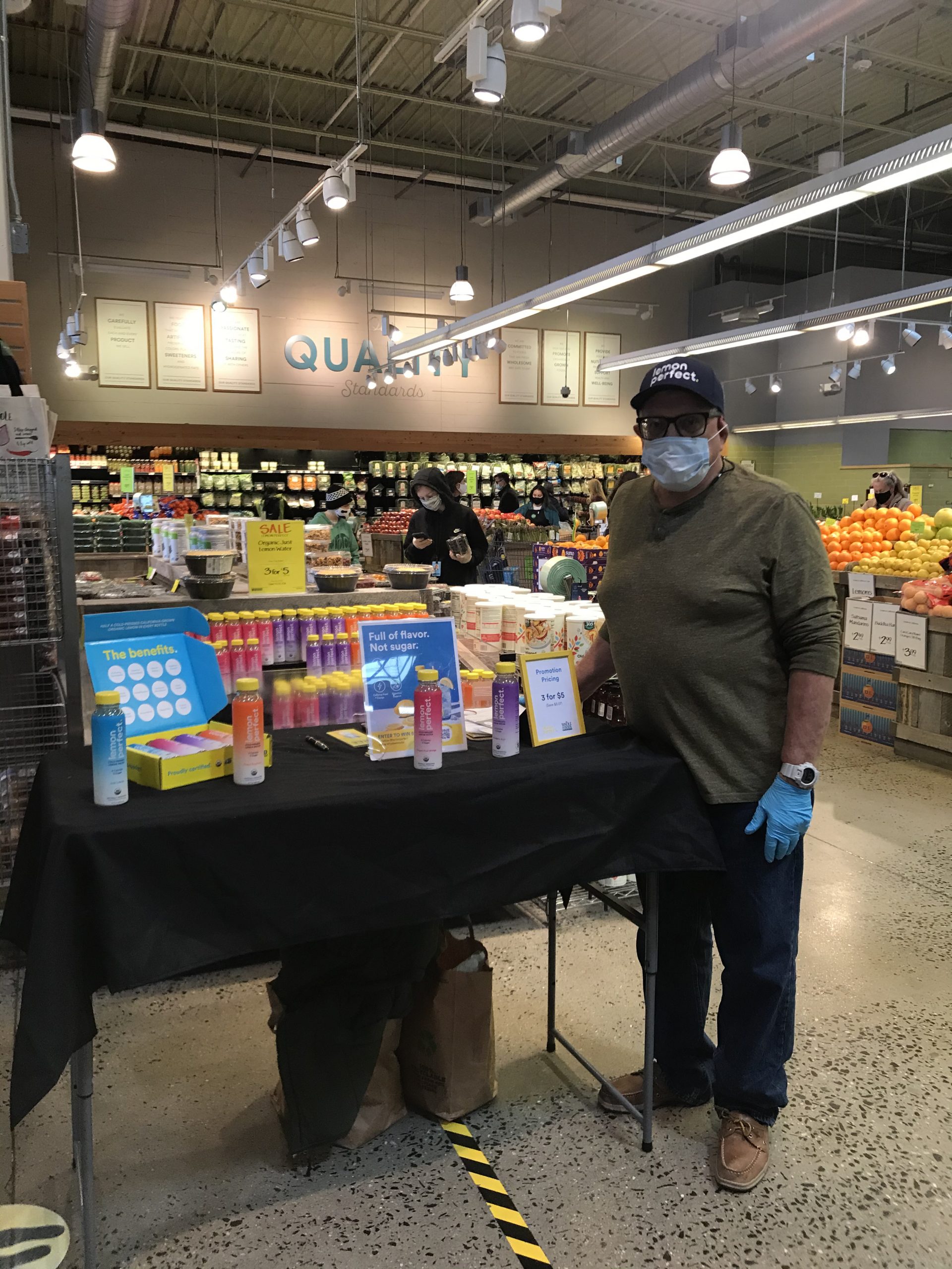 Man at grocery store product display table.